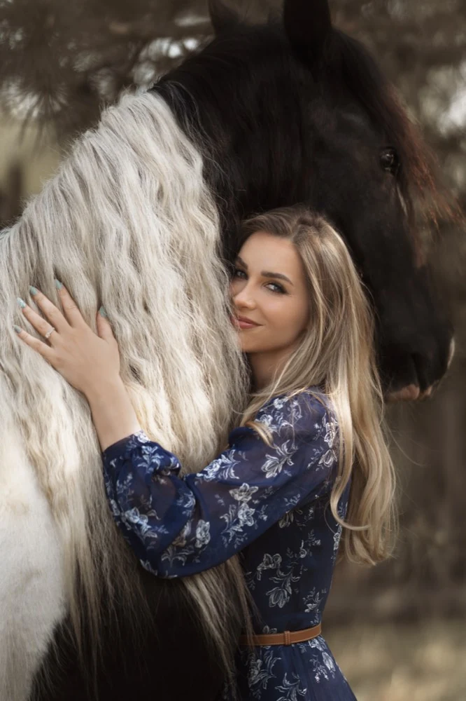 Žena objíma hrivu strakatého koňa